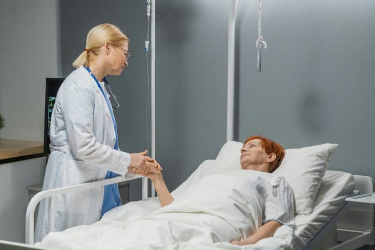 Chemopatientin liegt im Krankenhaus und hat Besuch von einer Ärztin